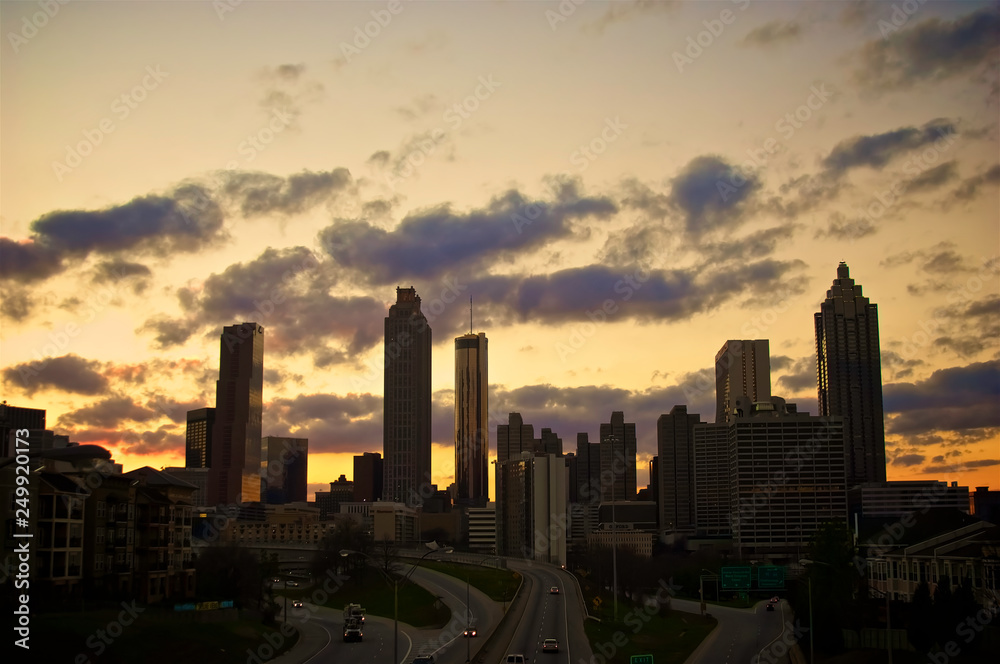 A dramatic silhouette of a cluster of buildings set against a golden sunset.