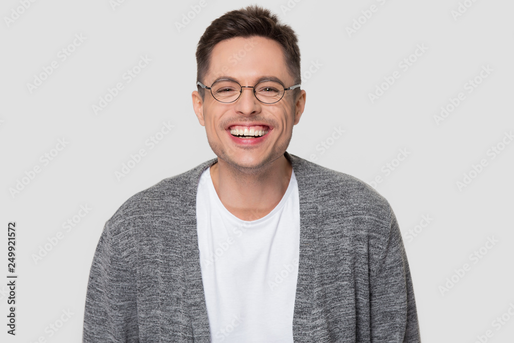 Fototapeta premium Funny happy millennial man wearing glasses laughing looking at camera