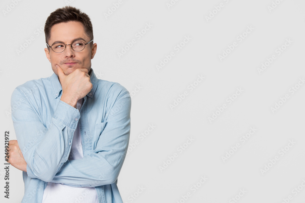 Thoughtful suspicious young man looking aside at copyspace feeling skeptic Thoughtful suspicious young man looking aside at copyspace feeling skeptic