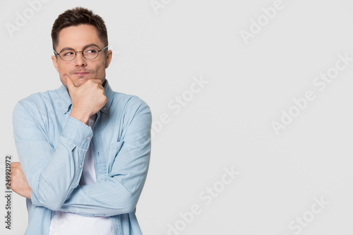 Thoughtful suspicious young man looking aside at copyspace feeling skeptic