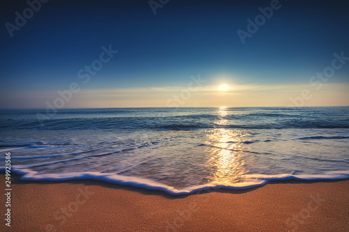 Sunrise over the sea and beach. Waves and sand..