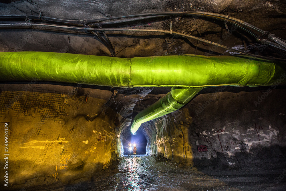 Miners inspecting an underground ventilation system in a gold mine in ...