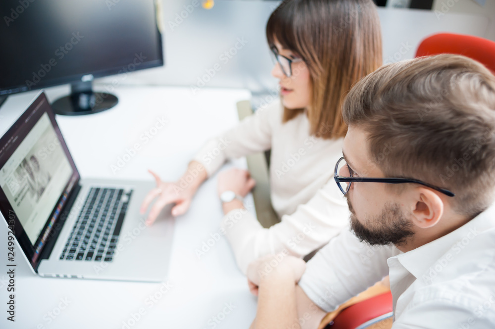 Fototapeta premium Young coworkers using laptop in office