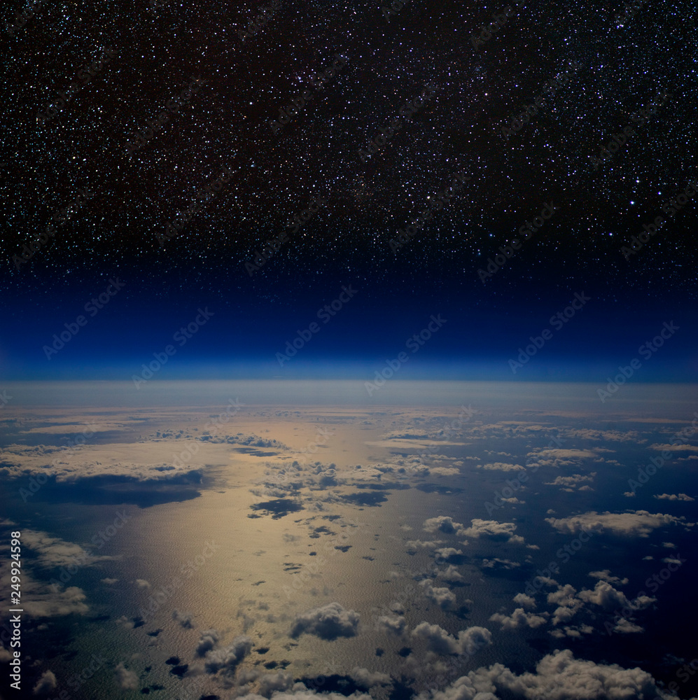 High altitude view of the Earth's surface with stars above.