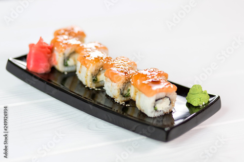 Sushi set with salmon, vasabi, ginger and sauce on black plate