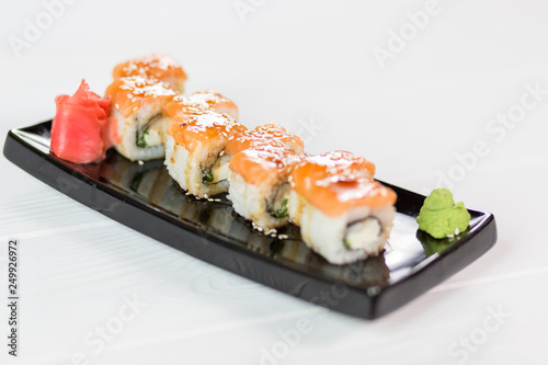 Sushi set with salmon, vasabi, ginger and sauce on black plate