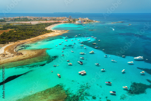 Boats and luxury yachts in transparent sea at sunset in summer in Mallorca, Spain. Aerial view. Colorful seascape with bay, azure water, sandy beach, blue sky. Balearic islands. Top view. Travel
