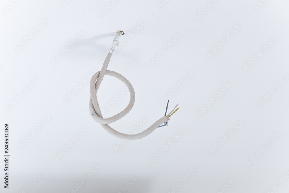 Ein Kabel hängt von der Decke. Stromanschluss für Licht bei der Renovierung Ein Kabel hängt von der Decke. Stromanschluss für Licht bei der Renovierung