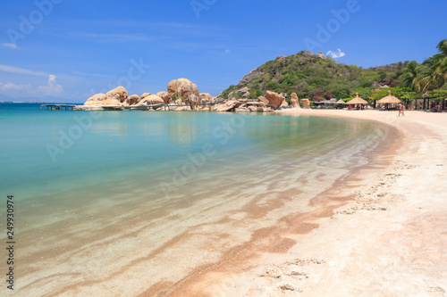 lagoon with clear blue water, tropical greenery and rocks with boulders