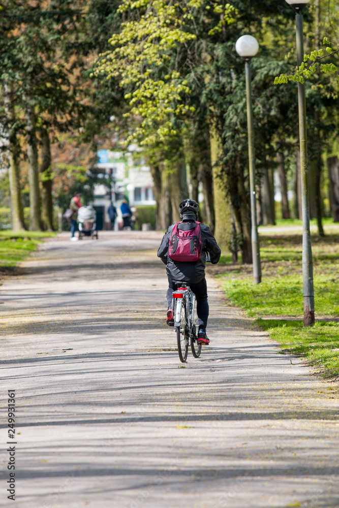 Fototapeta premium A person riding a bicycle through a park
