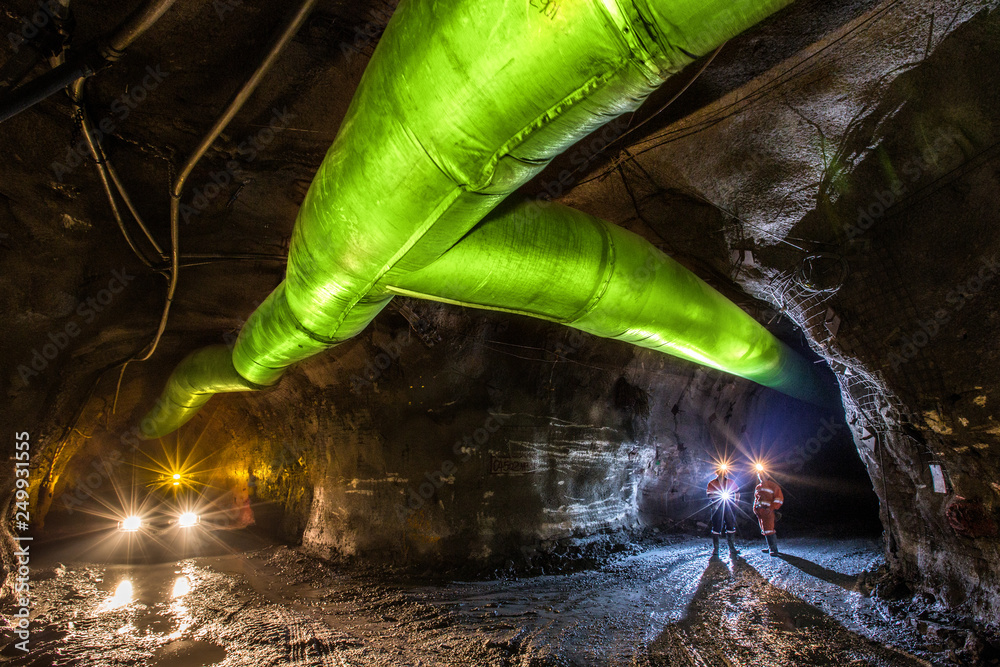 Miners inspecting an underground ventilation system in a gold mine in ...