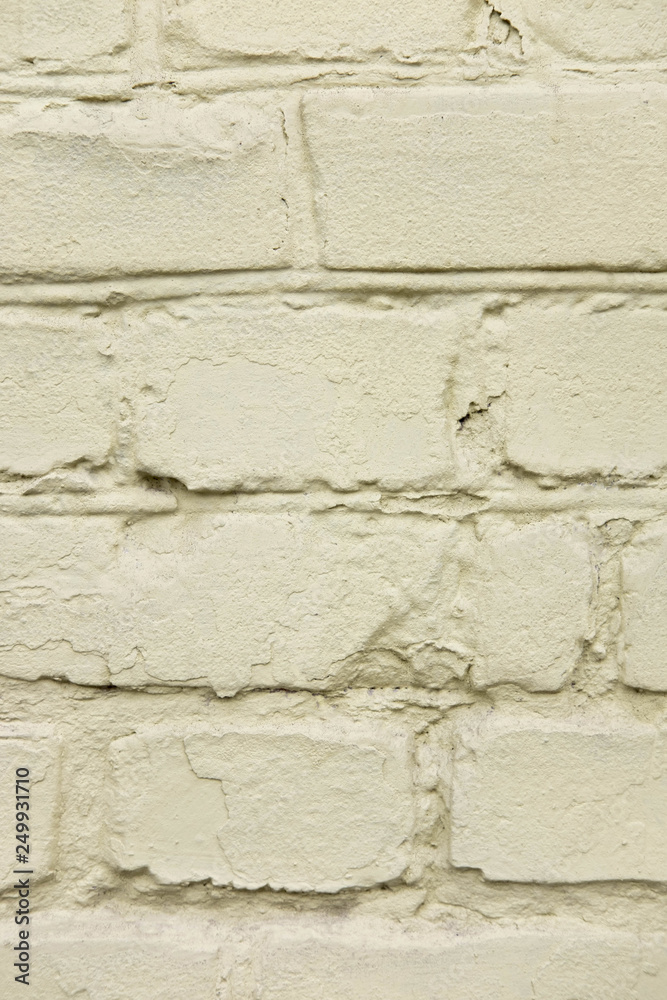 Obraz premium The texture of the old brick wall which is painted. Vertical photo of a brick wall. Texture for design