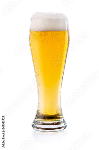 Cold light lager beer with drops and foam in glass. isolated