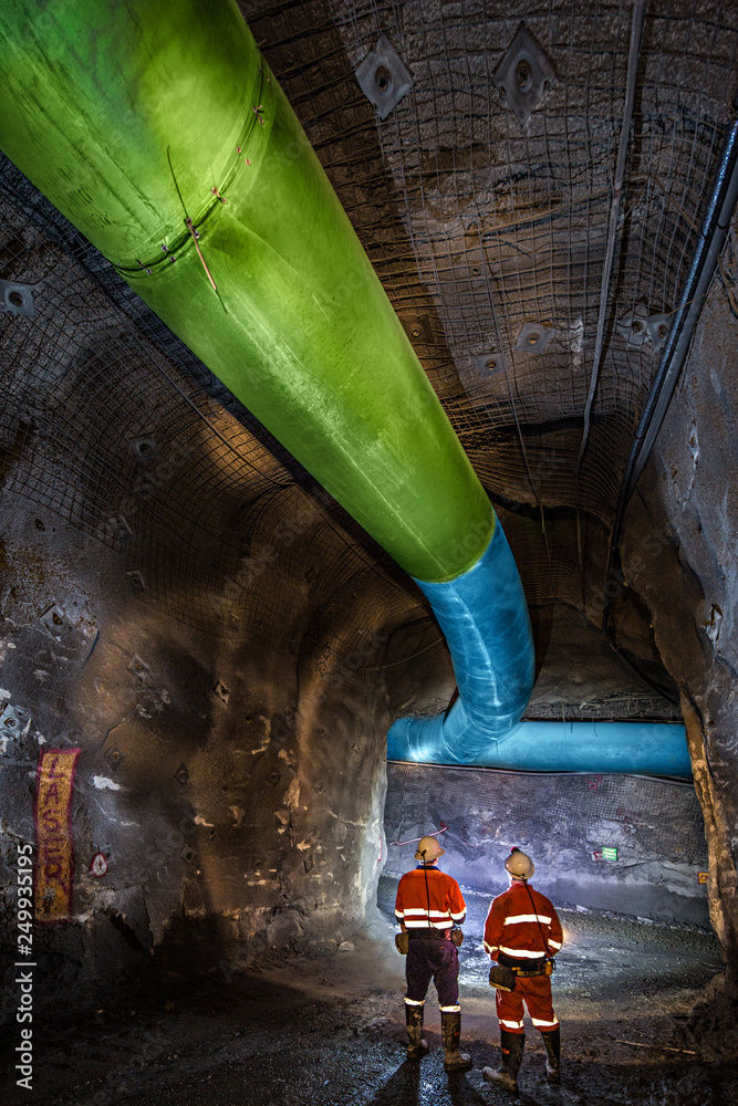 Miners inspecting an underground ventilation system in a gold mine in ...