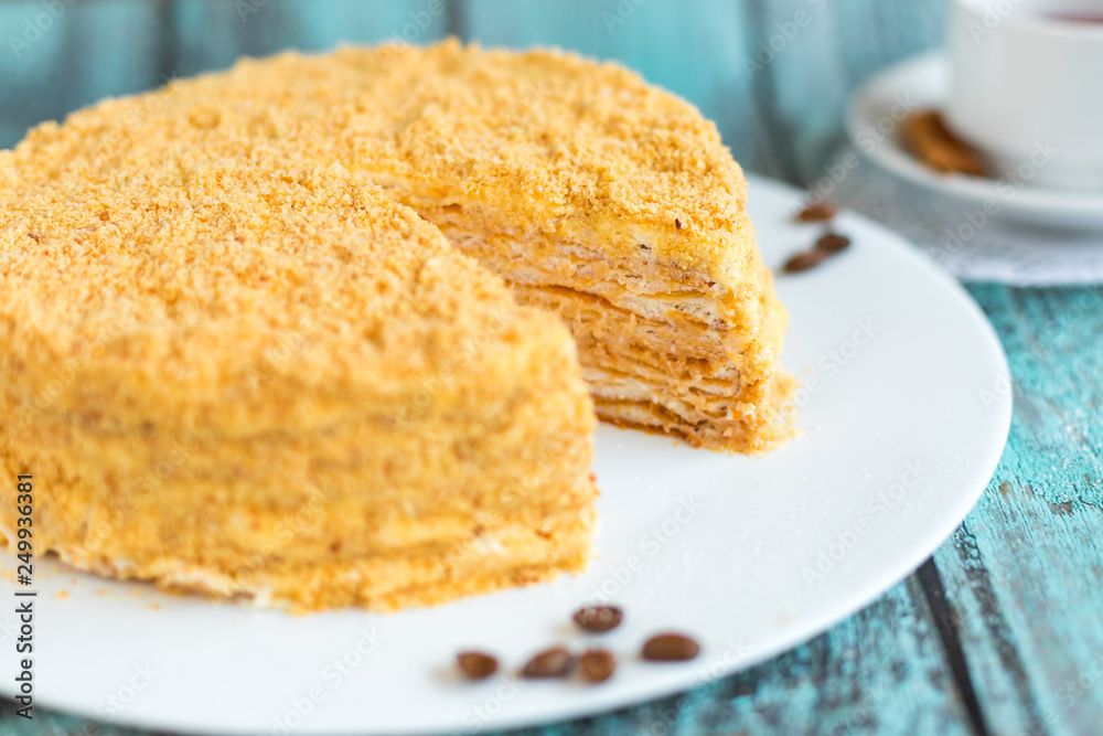 Honey cake on white plate on wooden table. Picture for a menu or a confectionery catalog Honey cake on white plate on wooden table. Picture for a menu or a confectionery catalog