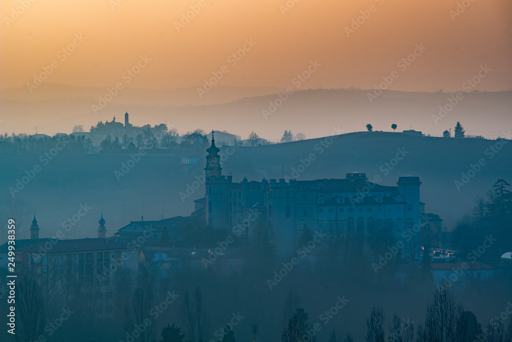 Castle of Costigliole d'Asti, Langeh and Monferrato region, Piedmont, Italy. Sunset time with foggy light