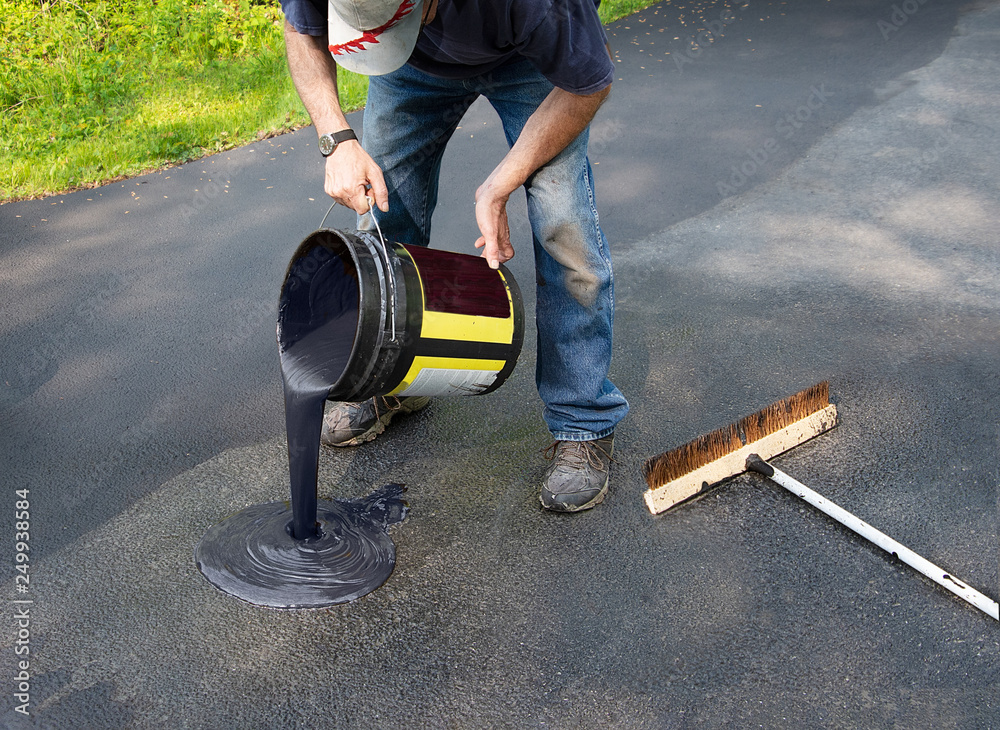 Pouring asphalt onto driveway for resealing Stock Photo Adobe Stock