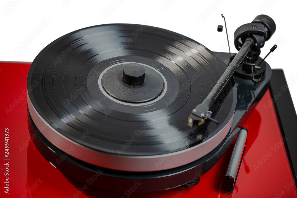 Close up view of audio record player with black vinyl disk on red surface isolated. Beautiful backgrounds. Close up view of audio record player with black vinyl disk on red surface isolated. Beautiful backgrounds.