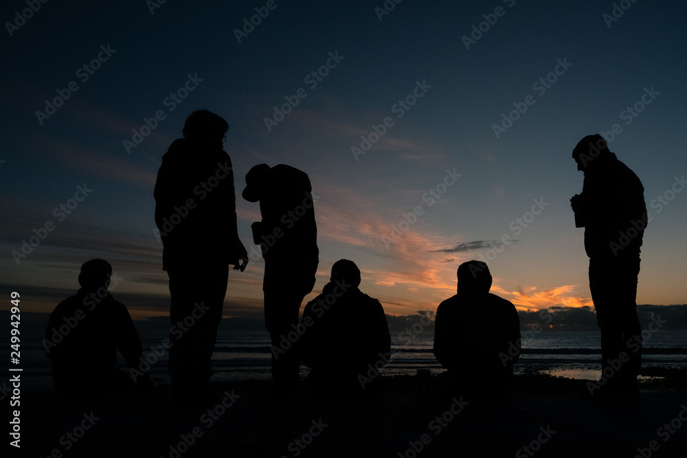 men at beach for sunset