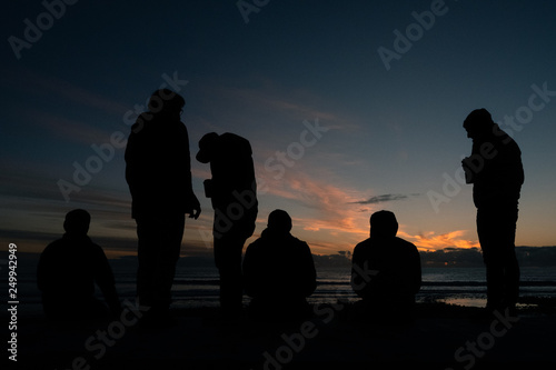 men at beach for sunset