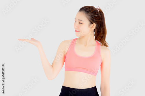 Beautiful portrait young asian woman in sport clothing with satisfied and confident presenting something empty on the hand isolated on white background, girl exercise for fit with health concept.