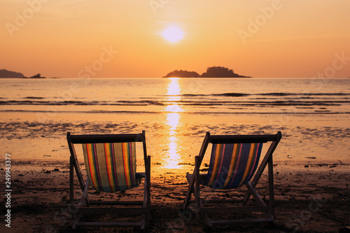 Couple of deck chairs at dusk on sea beach. © De Visu