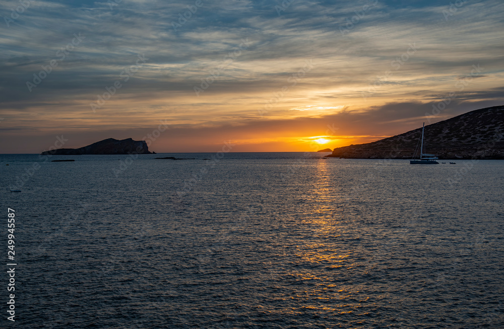 Island at sunset with beautiful sky from Cala Llentrisca , Ibiza .