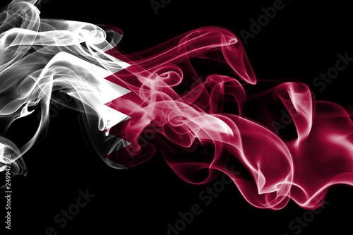 National flag of Qatar made from colored smoke isolated on black background. Abstract silky wave background.