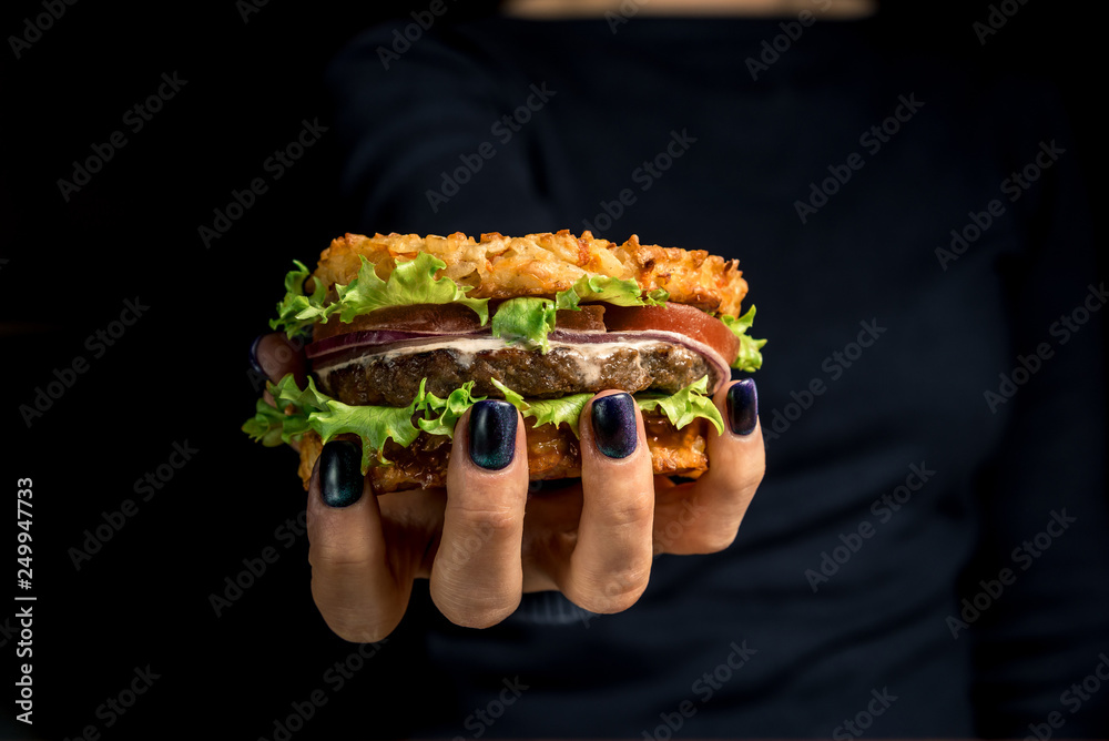 Healthy lifestyle, proper nutrition. Healthy rice burger with vegetables, herbs and cutlet in female hands