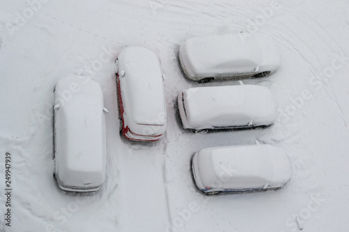 Five parked cars covered with snow during a Winter blizzard. Heavy storm making people leave their cars at home, for safety reasons. © k5hu