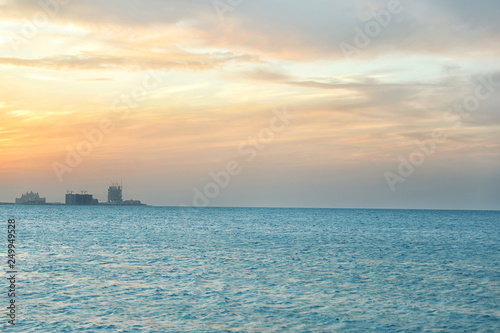 Beautiful view of sea, distant city on shore and amazing sunset sky