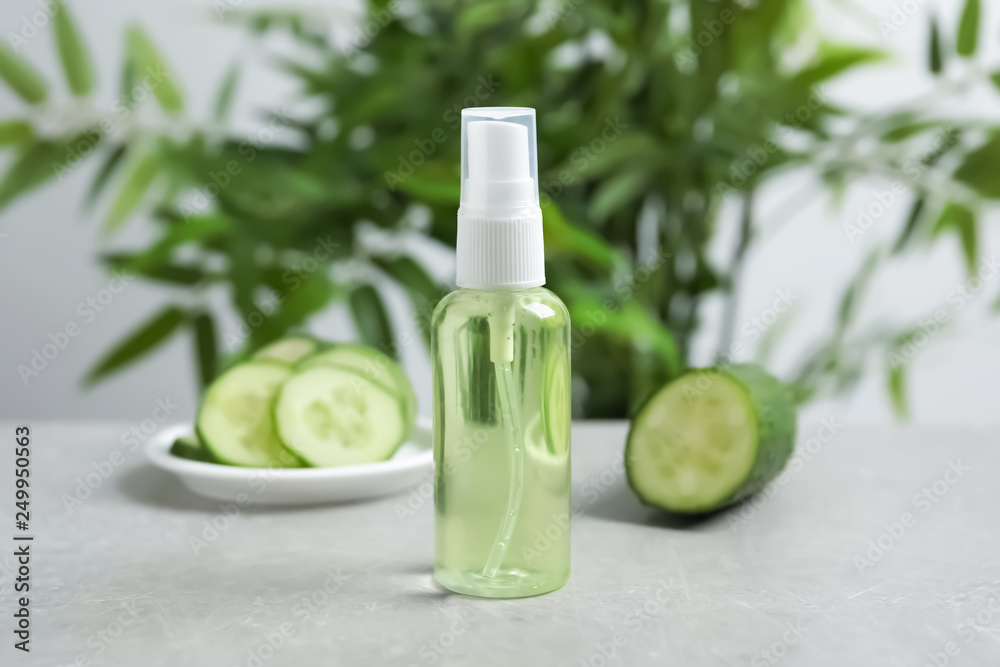 Cucumber tonic in bottle on table against blurred background - obrazy, fototapety, plakaty 