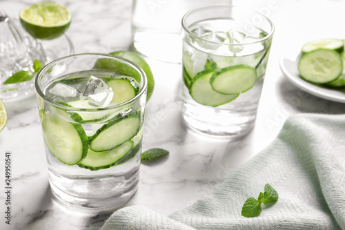 Glasses with fresh cucumber water on table. Space for text