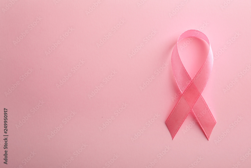 Pink ribbon on color background, top view with space for text. Breast cancer awareness concept