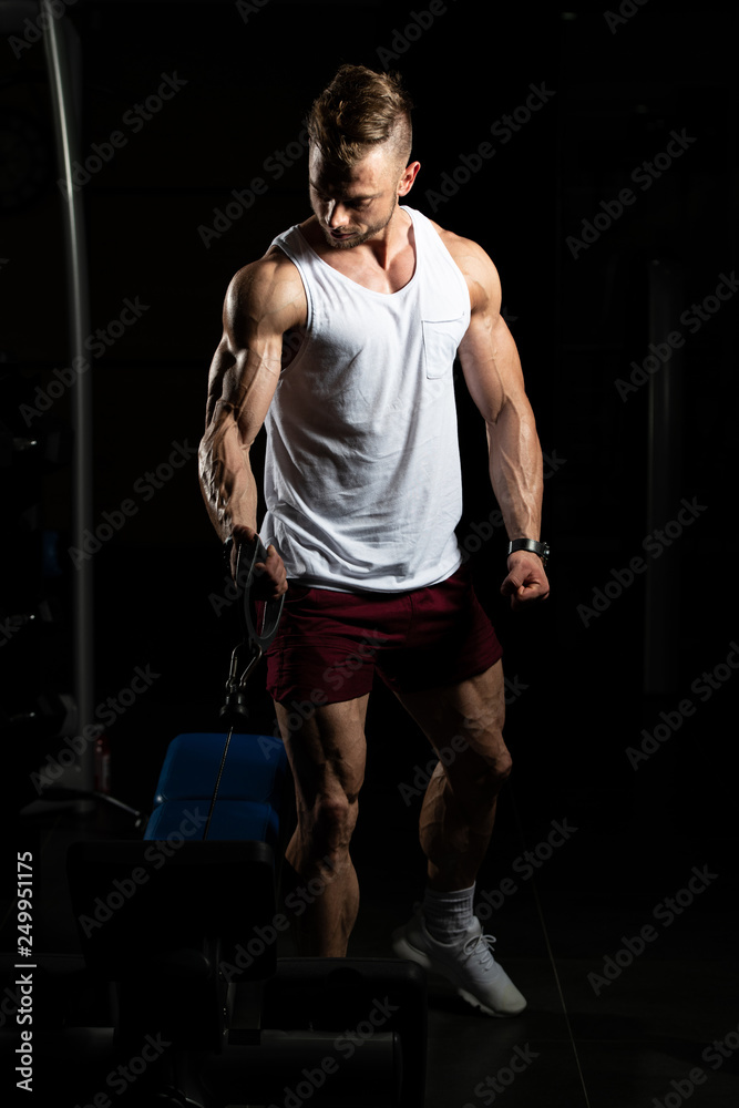 Bodybuilder Exercising Biceps In Undershirt