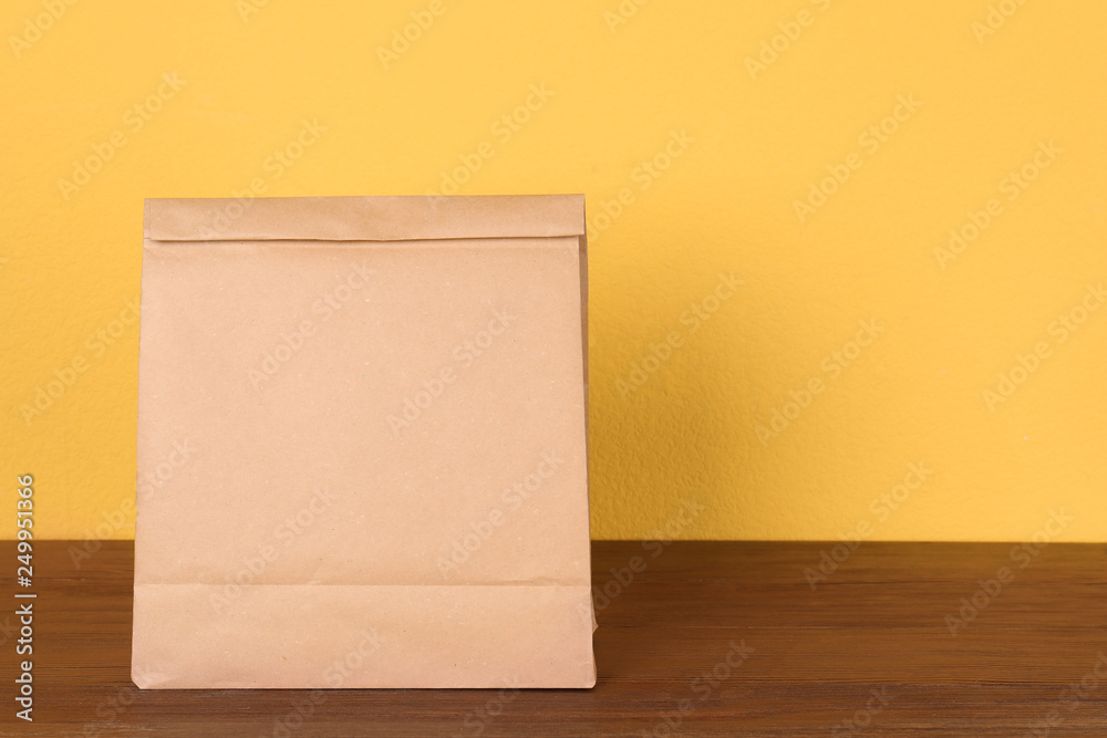Paper bag on table against color background. Mockup for design Paper bag on table against color background. Mockup for design