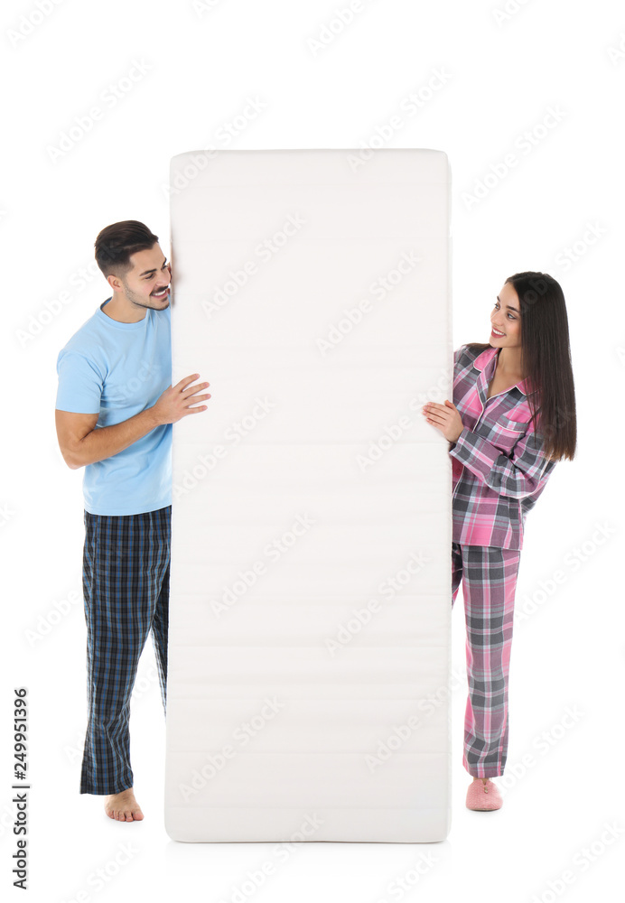 Young couple with comfortable mattress isolated on white Young couple with comfortable mattress isolated on white
