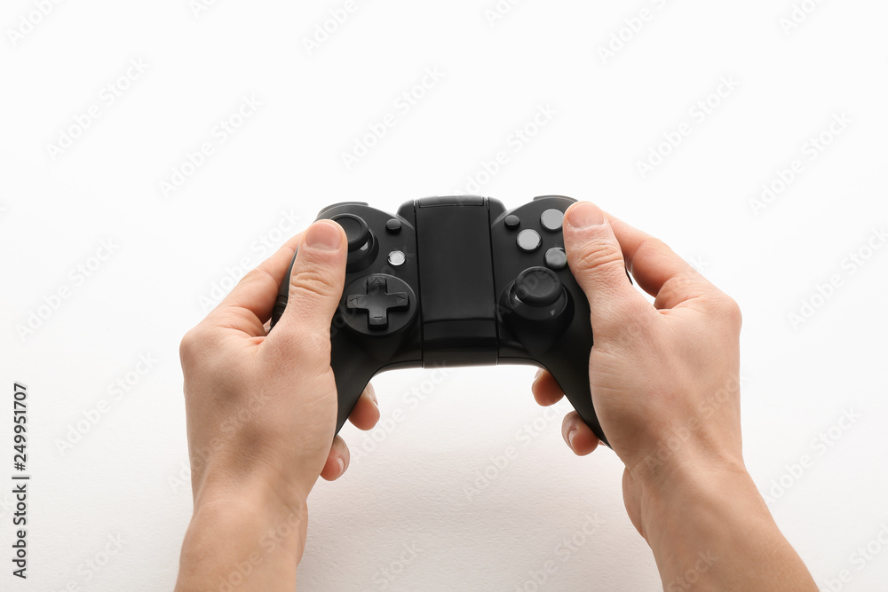 Young man holding video game controller on white background, closeup Young man holding video game controller on white background, closeup