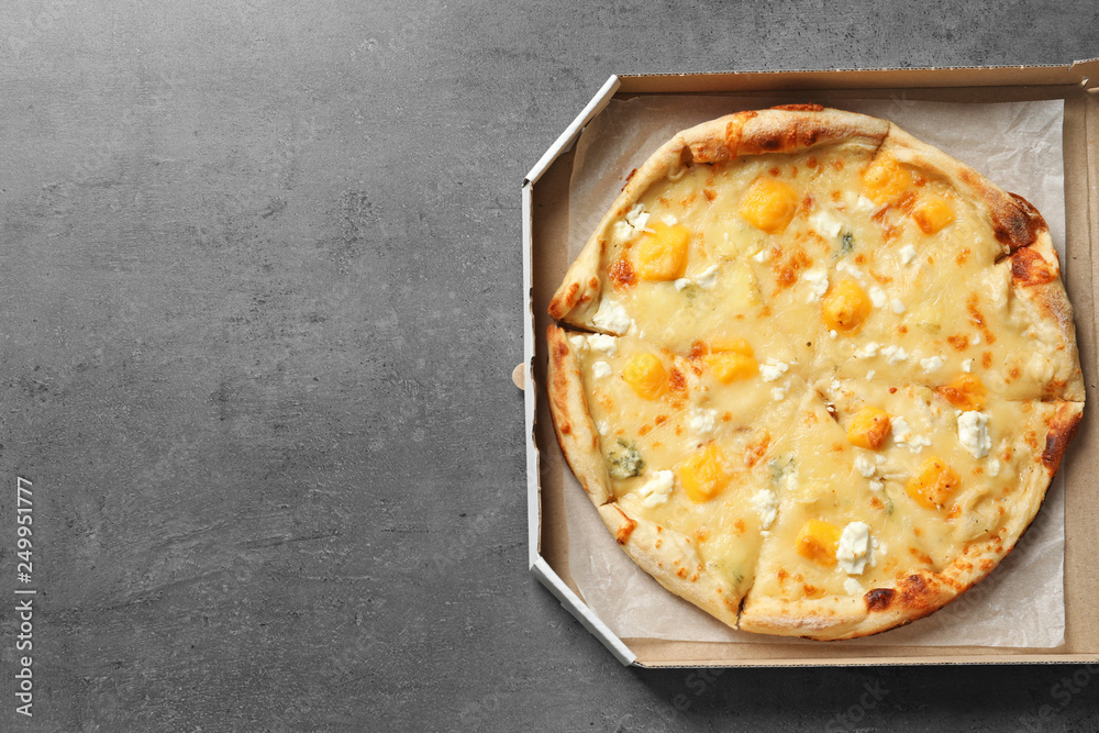 Cheese pizza in carton box on grey background, top view with space for text. Food delivery service