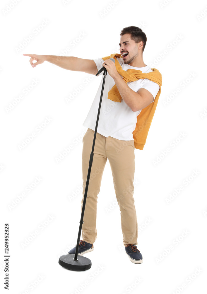 Young handsome man in casual clothes singing with microphone on white background