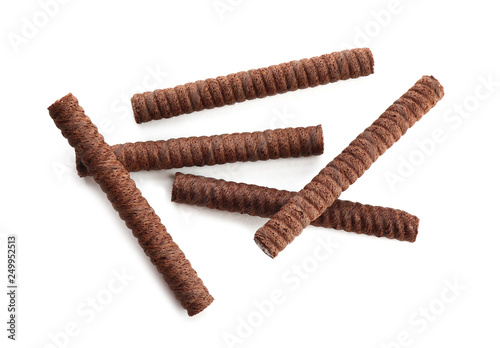 Delicious chocolate wafer rolls on white background, top view. Sweet food