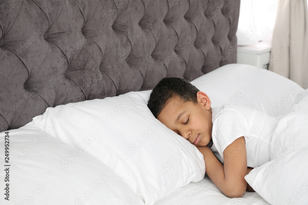 Cute little African-American boy sleeping in bed. Space for text Cute little African-American boy sleeping in bed. Space for text