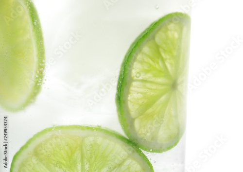 Drink with lime and ice cubes isolated on white, closeup