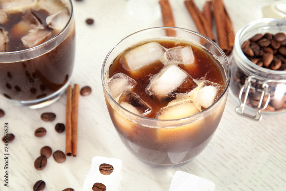 Glass of coffee drink with ice cubes on table