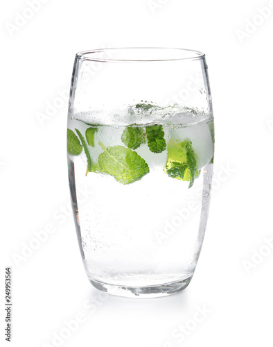 Glass of drink with mint and ice cubes on white background