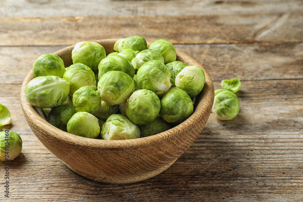 Bowl of fresh Brussels sprouts on wooden background. Space for text Bowl of fresh Brussels sprouts on wooden background. Space for text