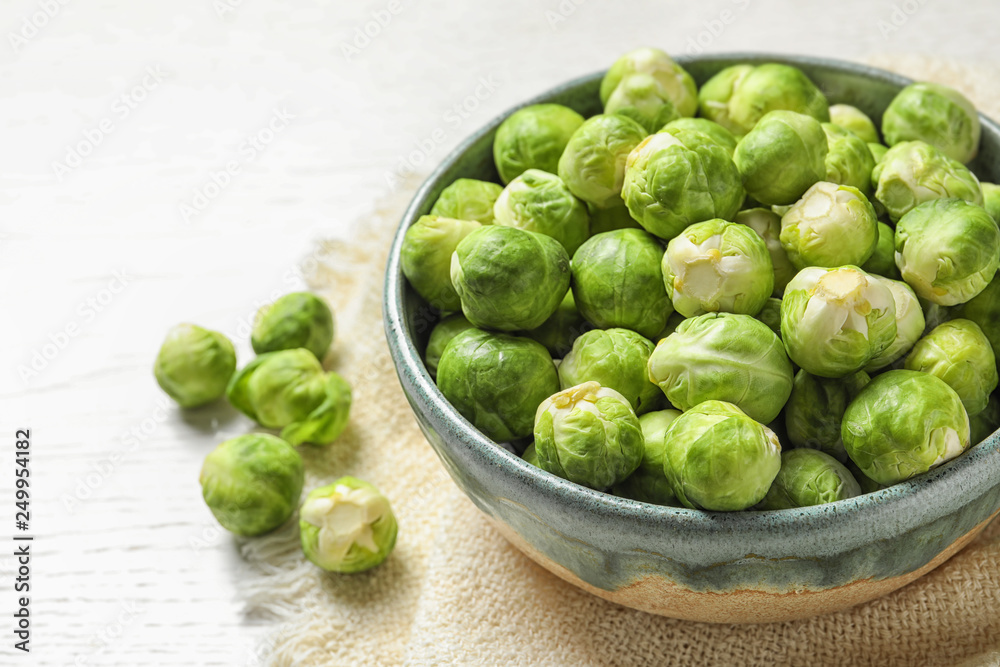 Bowl of fresh Brussels sprouts and napkin on table. Space for text Bowl of fresh Brussels sprouts and napkin on table. Space for text