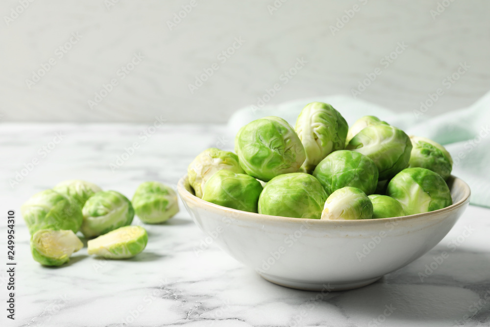 Bowl with fresh Brussels sprouts on marble table. Space for text Bowl with fresh Brussels sprouts on marble table. Space for text