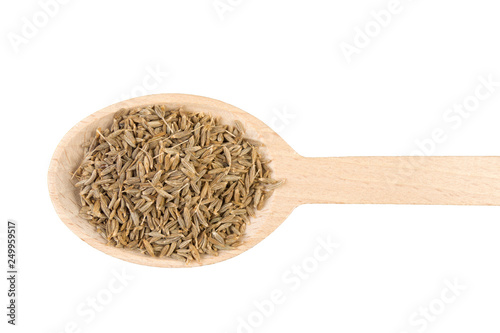 cumin in wooden spoon isolated on white background. Closeup.