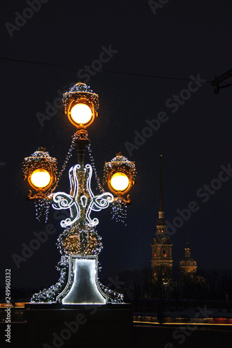 Russia, St. Petersburg, a lantern on the Trinity Bridge on the background of the Peter and Paul Fortress at night photo